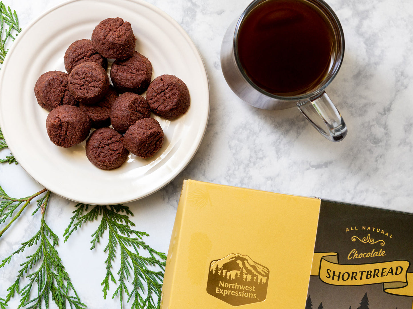 table set with chocolate shortbread cookies, a cup of coffee and an elegant gift box