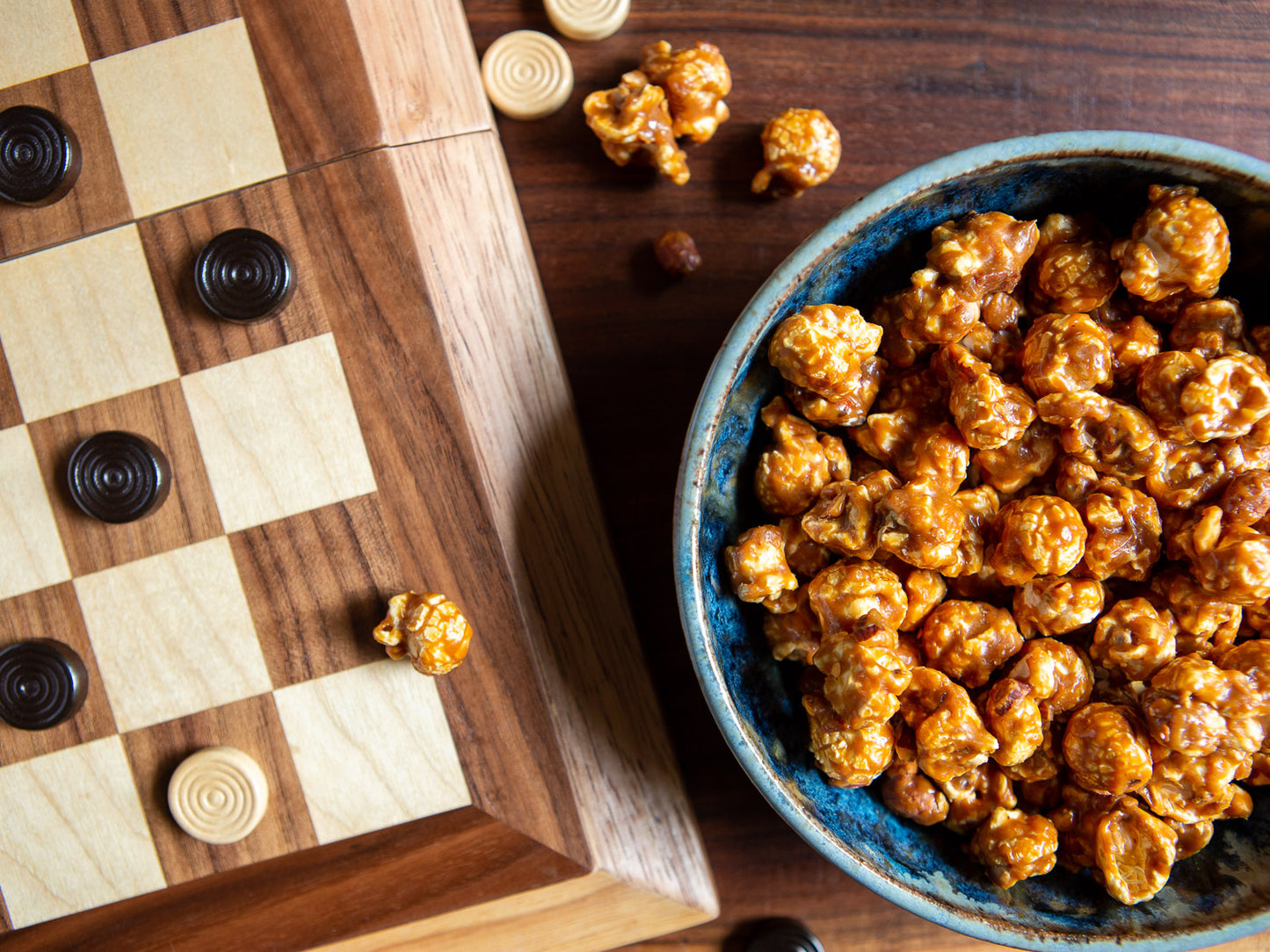 someone enjoying a game of checkers with toffee pop gourmet popcorn