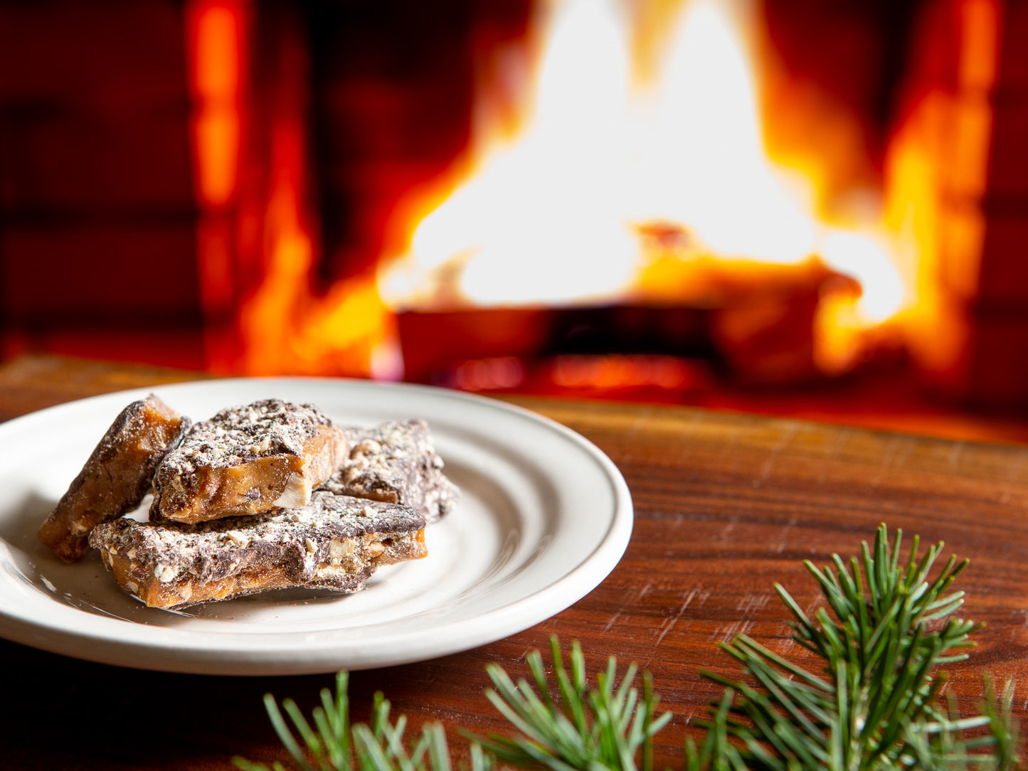 toffee pieces on a saucer in front of a cozy, roaring fire