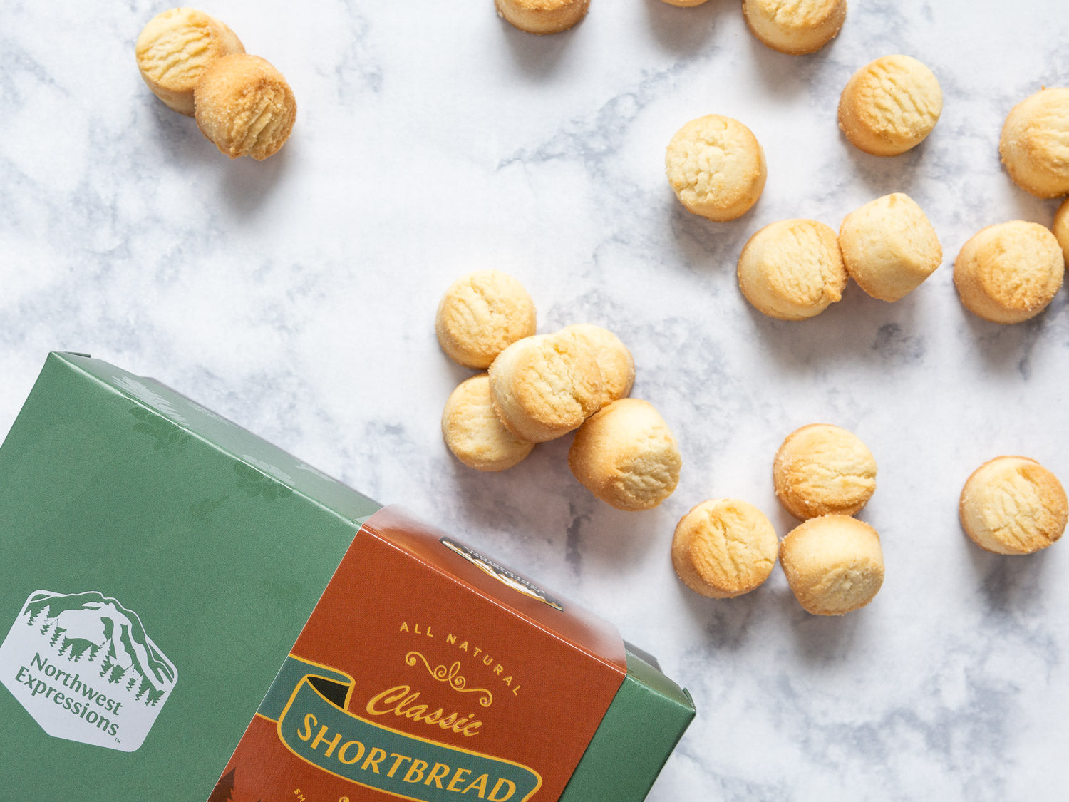 classic shortbread scattered across a marble countertop beside the gift box