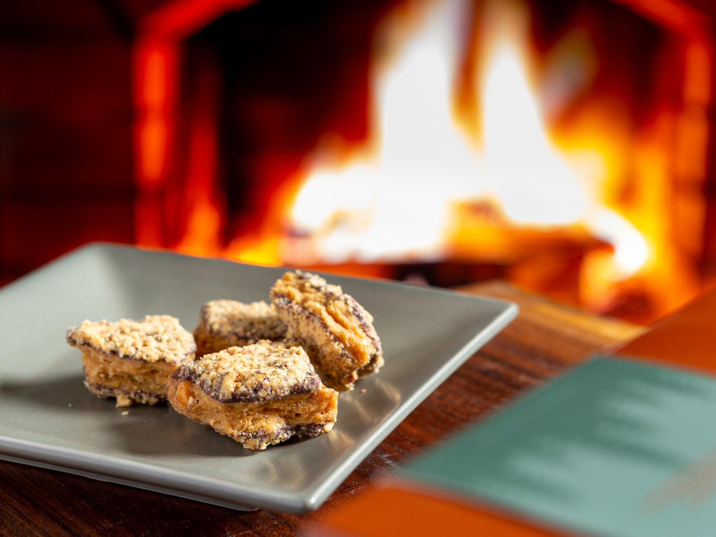 soft peanut butter brittle dipped in dark chocolate beside a cozy fireplace