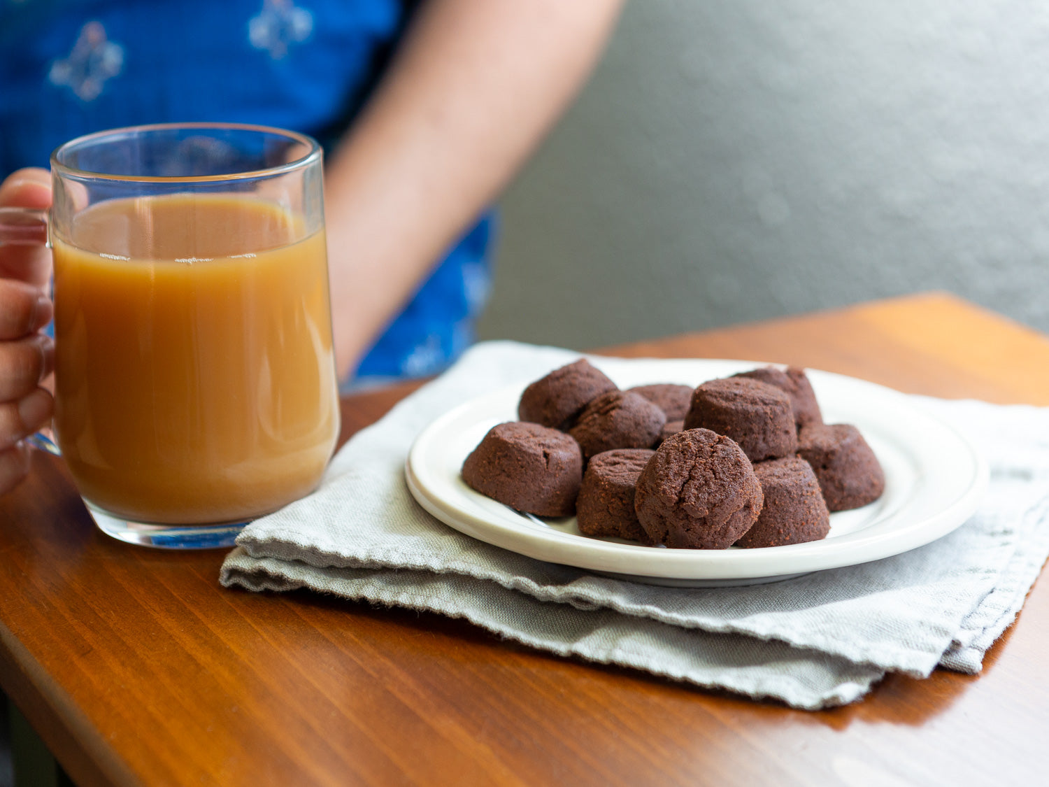a woman enjoying chocolate shortbread cookies with a big cup of coffee